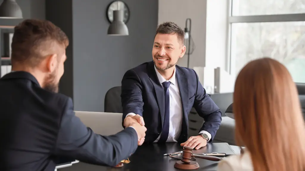 Business professional shaking hands with a client after a successful proposal meeting.